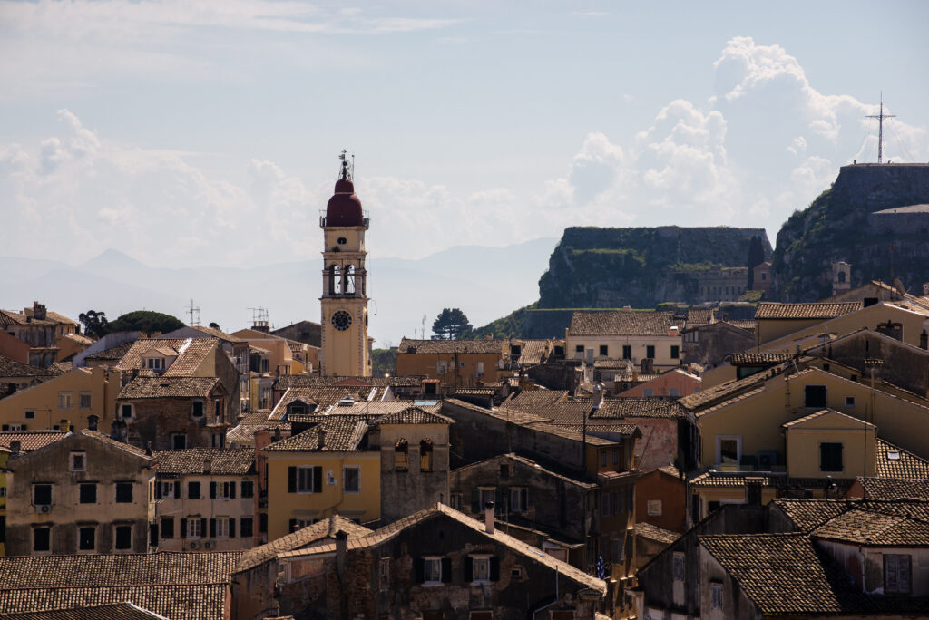 Town with a red-roofed tower against a mountain backdrop